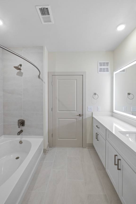 A white bathroom with a tub, sink, and mirror.