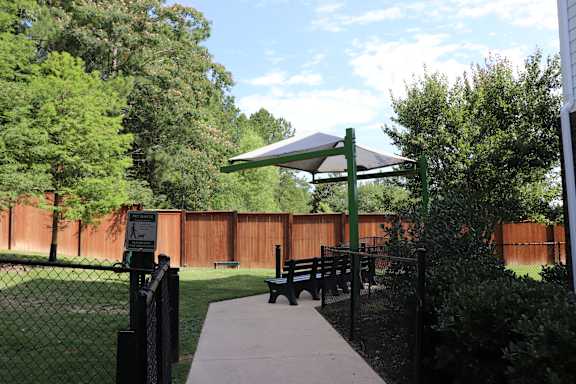 a picnic area in a park with a bench and a canopy at The Met Apartment Homes, Hattiesburg, 39402