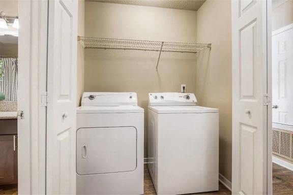 A small laundry room with a washer and dryer at Reserve at Gulf Hills Apartment Homes in Ocean Springs, MS