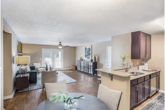 A modern kitchen with a dining table and chairs and hardwood floors at Reserve at Gulf Hills Apartment Homes in Ocean Springs, MS