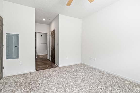 an empty living room with white walls and a door to a hallway at The Met Apartment Homes, Mississippi