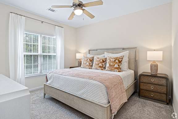 a bedroom with a bed and a ceiling fan at The Met Apartment Homes, Mississippi 39402