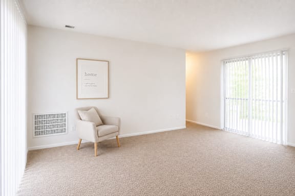 A room with a framed picture on the wall and a chair in it.