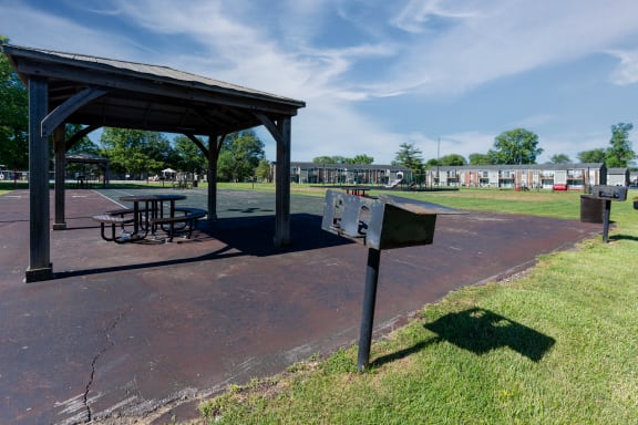 a picnic area with a table and a mailbox in a park