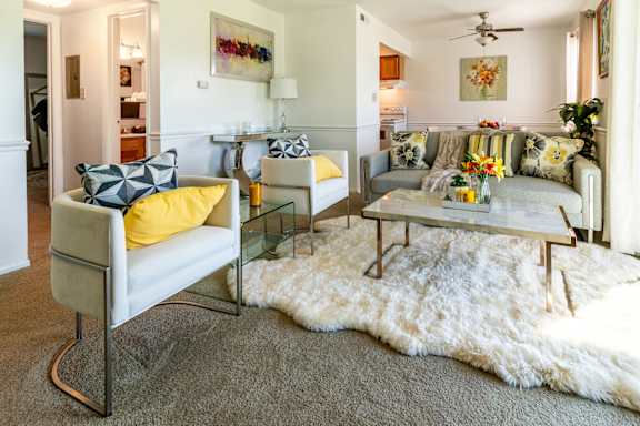 a living room with couches and chairs and a rug