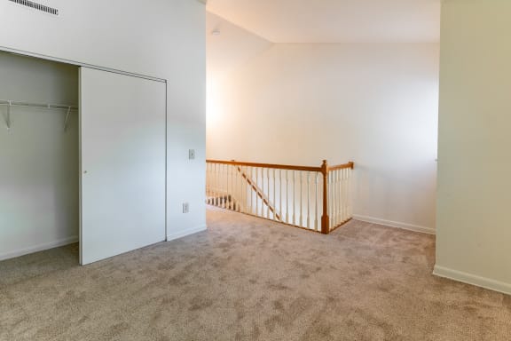 an empty room with a staircase and a closet