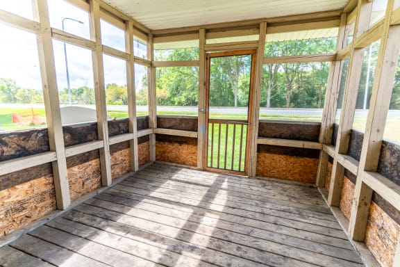 the inside of a screened in porch with a tub and windows