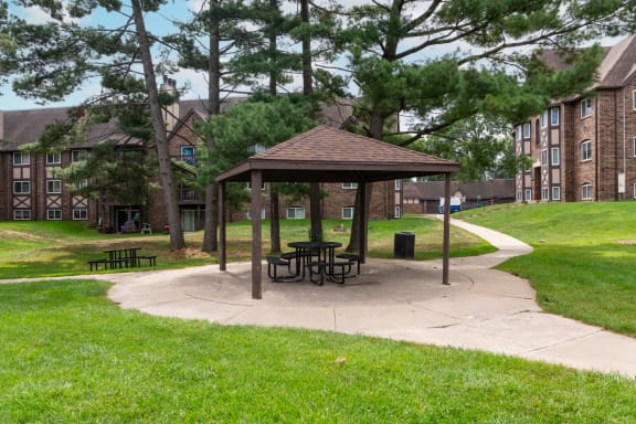 a picnic area with a gazebo in front of an apartment building