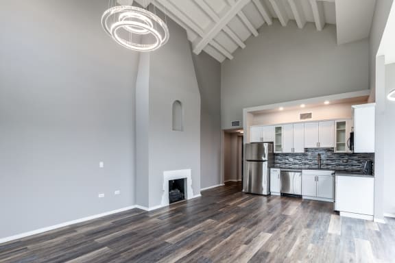 a living room with a fireplace and a kitchen