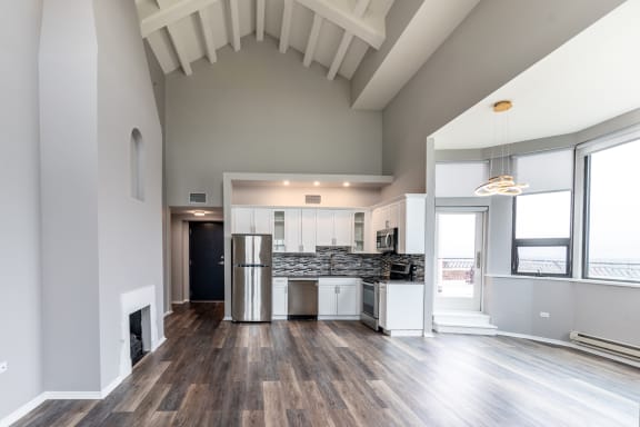 a living room with a kitchen and a large window