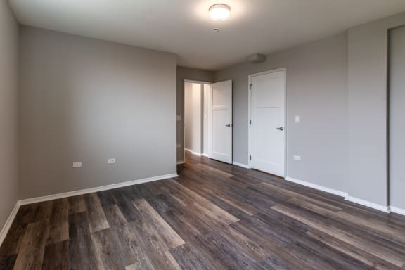 a living room with wood flooring and white walls and doors