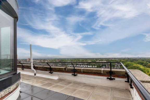 a balcony with a view of a city and a blue sky