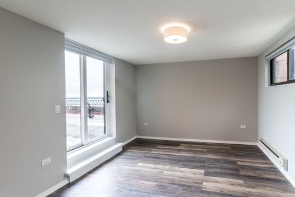 a living room with a large window and wood flooring
