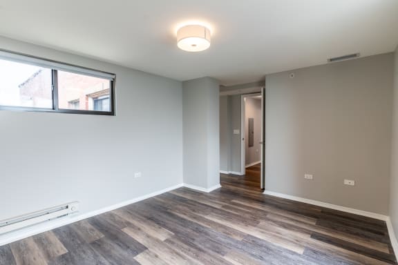 a living room with wood flooring and a large window