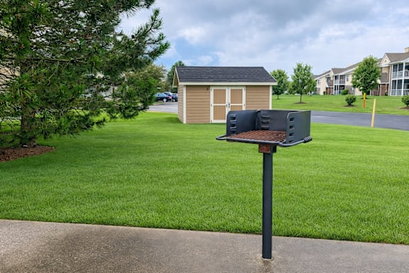 A mailbox sits on a pole in front of a green lawn.