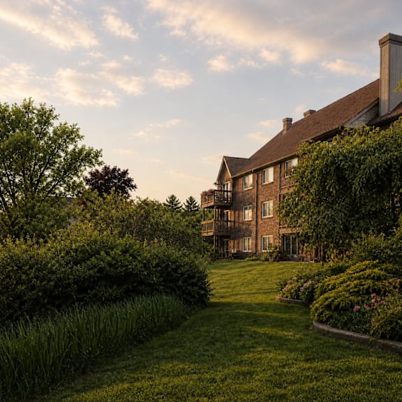A large house with a well-manicured lawn and a variety of shrubbery.