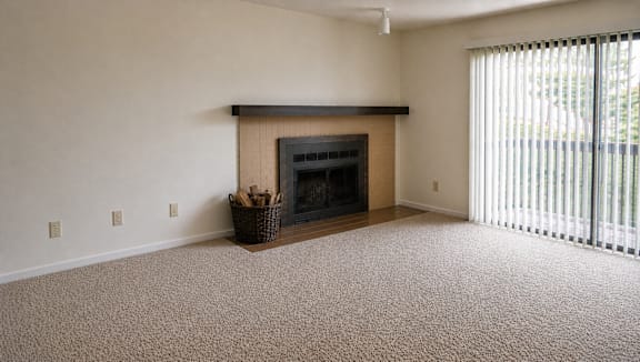 A room with a fireplace and carpeted floor.