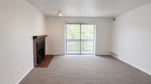 A room with a fireplace and carpeted floor.