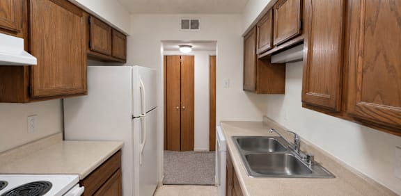 A kitchen with wooden cabinets and a white refrigerator.