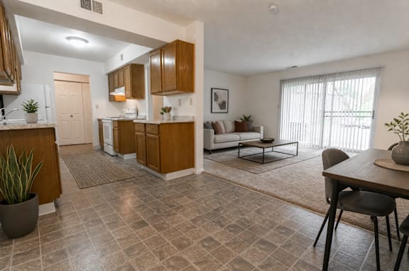 A kitchen with brown cabinets and a tiled floor.