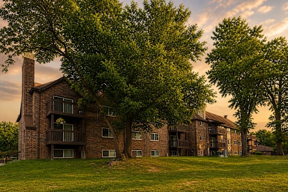 A large brick building with a green lawn in front.