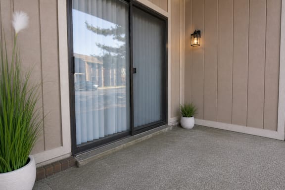A glass door with a handle is on the left and a wall light is on the right.