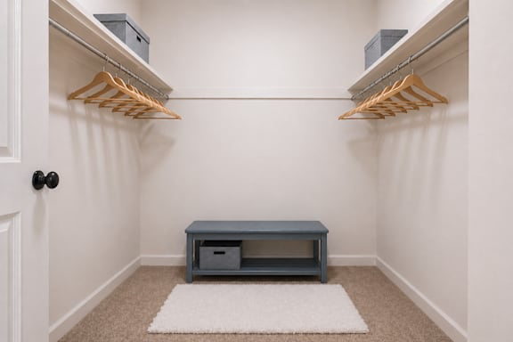 A white rug is on the floor in front of a bench and a coat rack.