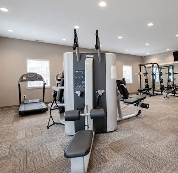 A gym with a treadmill, elliptical trainer, and other exercise equipment.