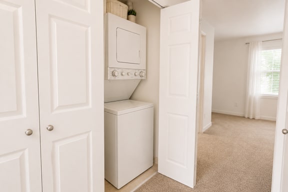 A white oven and dishwasher are built into a wall in a small room.