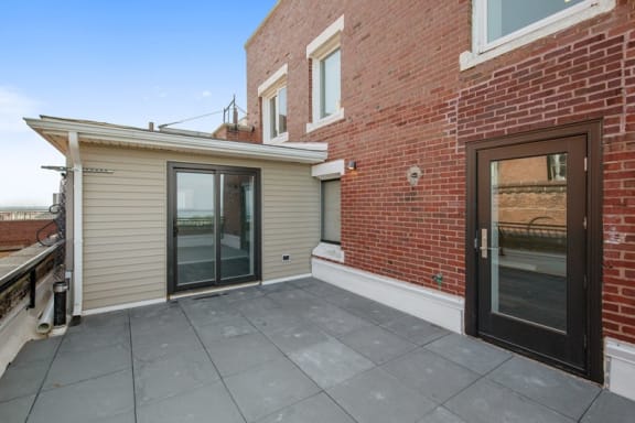 a patio with a brick wall and glass doors