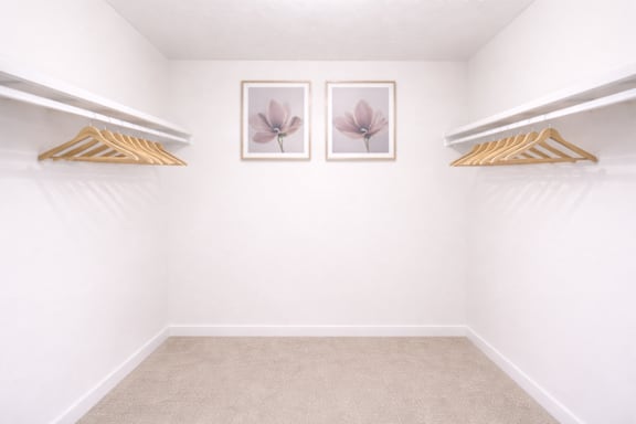 A room with two framed pictures of flowers on the wall.
