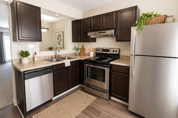 A kitchen with dark brown cabinets and stainless steel appliances.