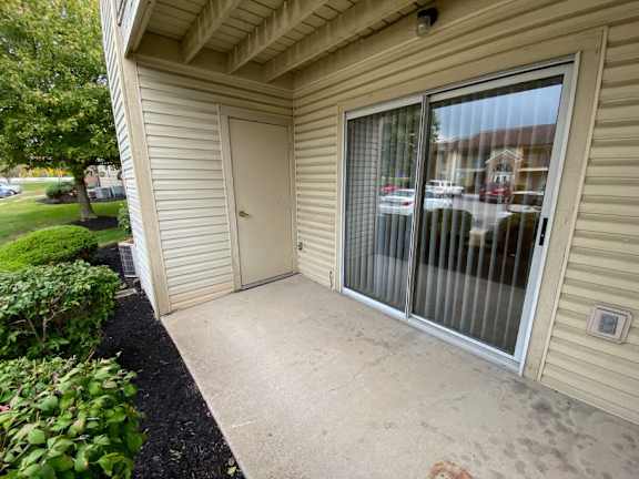 a patio in front of a house with a door at Creekside Square Apartments, Indianapolis, IN 46254