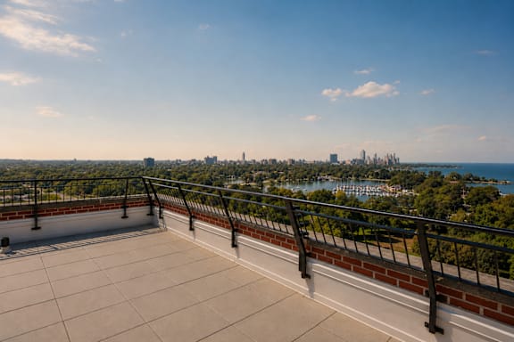 A balcony overlooks a cityscape and a body of water.