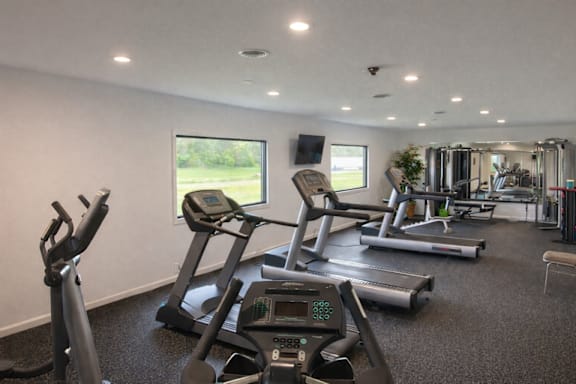 A gym with treadmills, elliptical machines, and other exercise equipment.