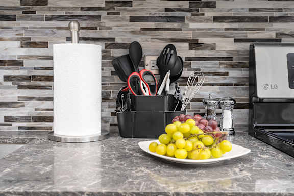a kitchen counter with a plate of fruit and a roll of paper towels at Park Heights by the Lake Apartments, Chicago, 60649