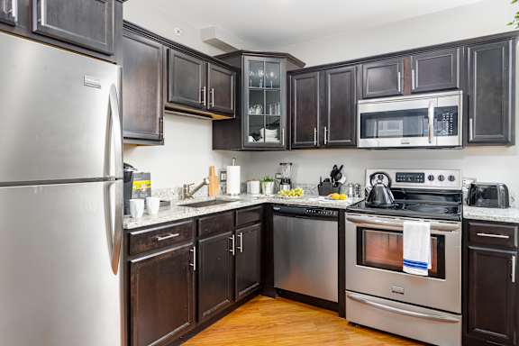 Kitchen with stainless steel appliances and black cabinets at Somerset Place Apartments, Chicago, 60640
