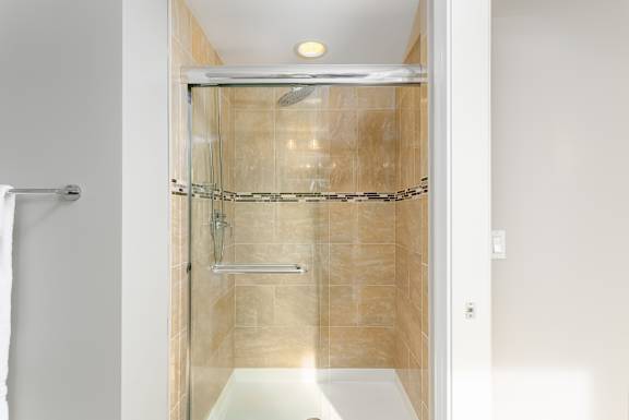Shower with a glass door in a bathroom at Somerset Place Apartments, Illinois, 60640