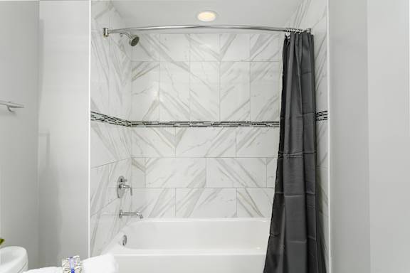 Bathroom with a bathtub and curtain at Somerset Place Apartments, Illinois
