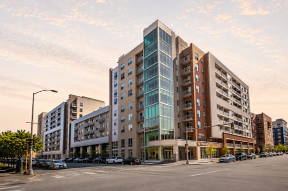 A modern multi-story building with a glass facade is the focal point of the image.