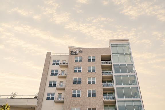 A tall building with a balcony on the top floor.