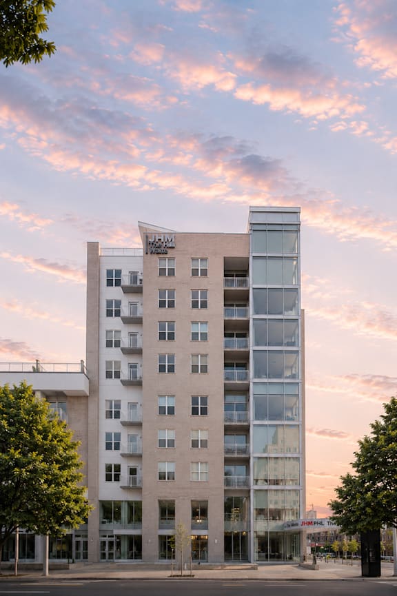 A modern apartment building with a curved glass addition on the top floor.