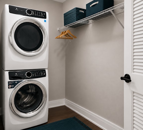 A white front load washing machine in a laundry room.