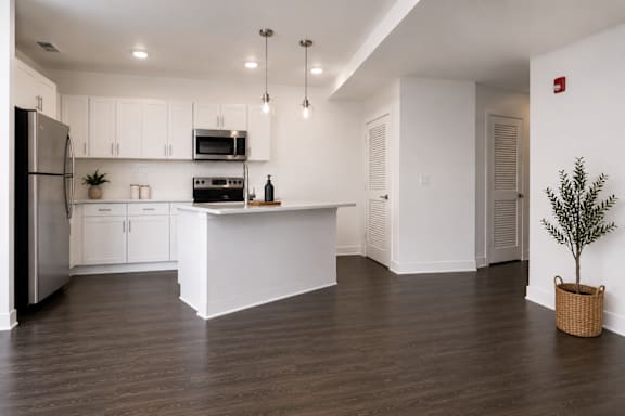 A kitchen with white cabinets and a black refrigerator.