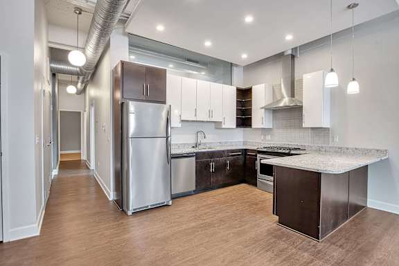 Modern kitchen with white and dark cabinetry and granite countertops at The Lofts at Elk Terminal Apartments, Buffalo, 14204