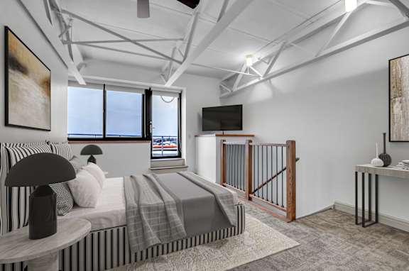 Floor Plan  a bedroom with a bed and a tv in a loft at 100 South Apartments, Buffalo