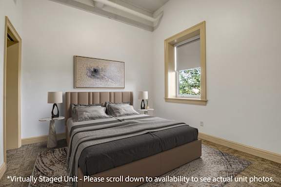 A bedroom with a large bed and a painting above it.