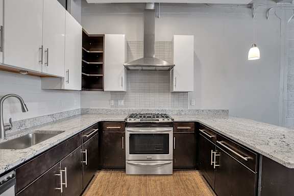 Contemporary kitchen with granite countertops and stainless steel range at The Lofts at Elk Terminal Apartments, Buffalo, New York