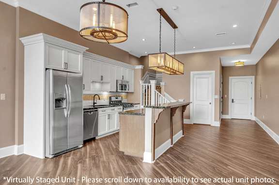 A modern kitchen with wooden floors and stainless steel appliances at The Knights @ 506 Delaware Apartments, Buffalo, NY