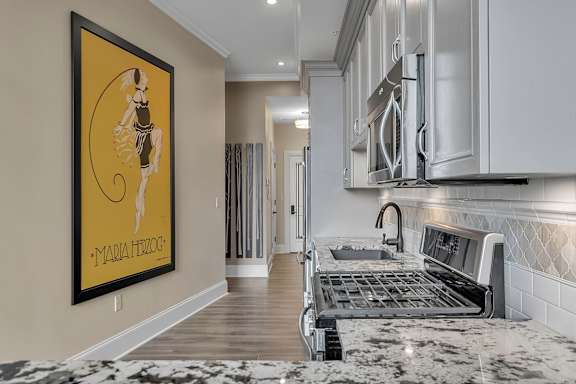 A kitchen with a framed picture of a woman on the wall.